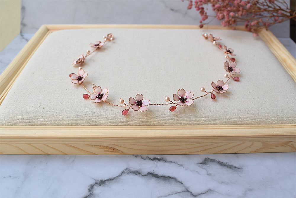 A Delicate 18 inches bridal hair vine in rose gold finish with handmade tiny Sakura/Cherry Blossom flowers in arranged in a row in combination with pink pearls and glass beads. A unique bridal pink hair wrap or hair garland in rose gold finish.