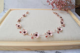 A Delicate 18 inches bridal hair vine in rose gold finish with handmade tiny Sakura/Cherry Blossom flowers in arranged in a row in combination with pink pearls and glass beads. A unique bridal pink hair wrap or hair garland in rose gold finish.